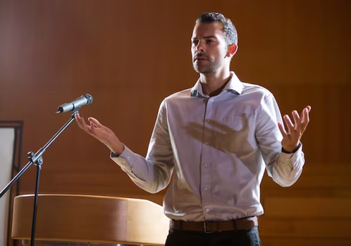business-executive-gesturing-while-giving-speech-conference-center_107420-96680